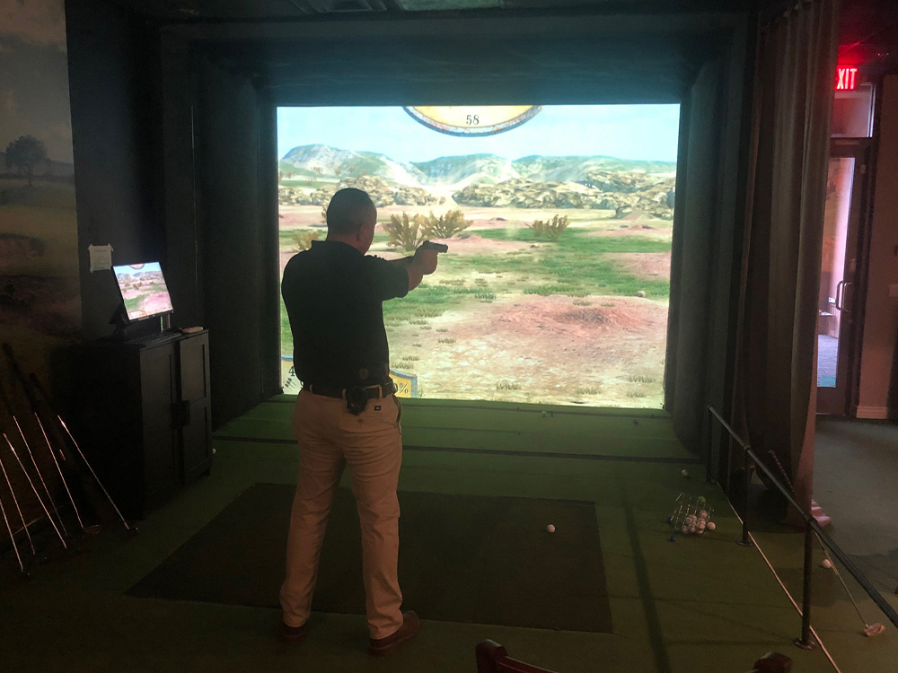 A participant on the shooting simulator at Sticks Golf & Cigar Lounge