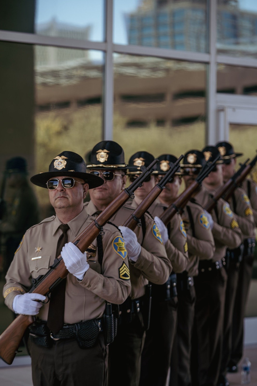 The MCSO honor guard standing in formation with rifles at a memorial ceremony